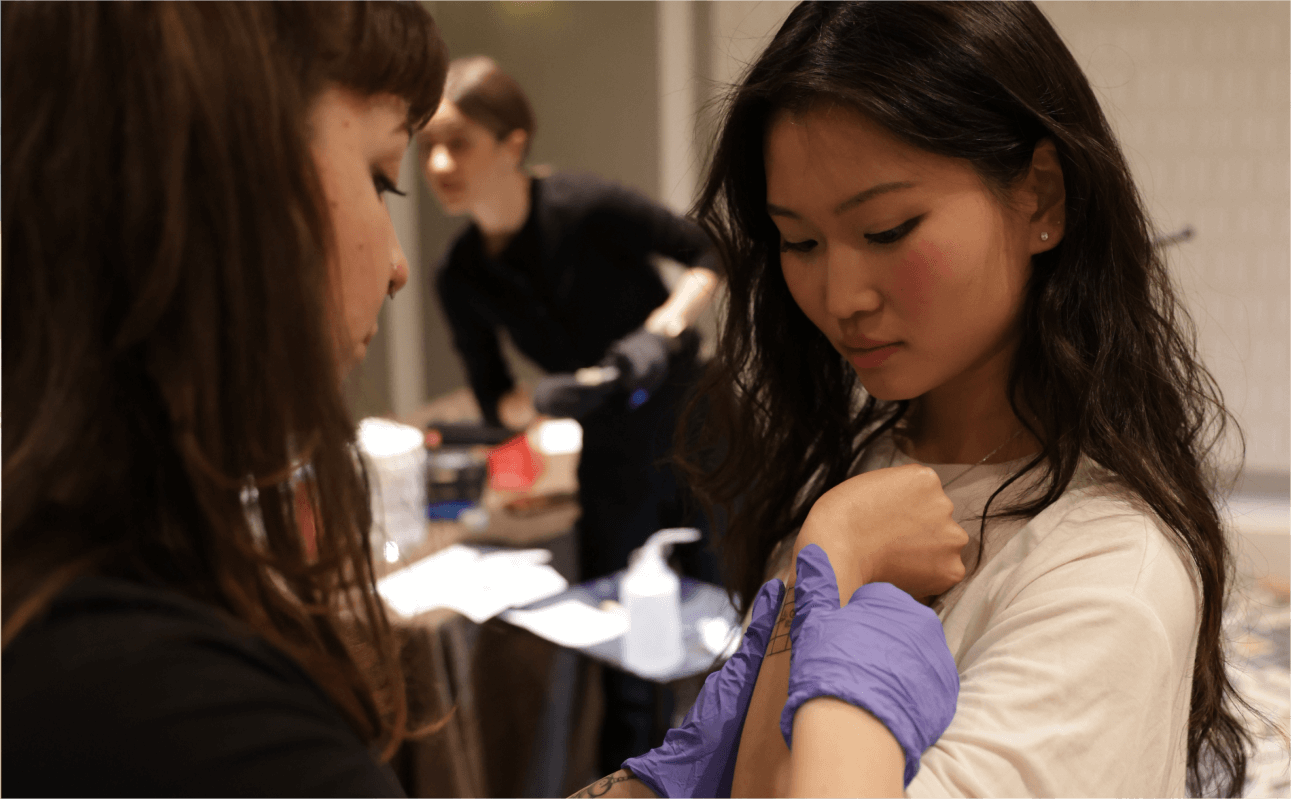 Tattoo artist creating bespoke tattoos for guests at a private party, adding an extra touch of uniqueness and personalization to the event.